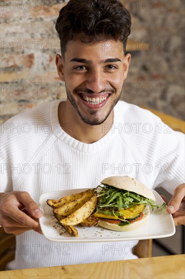 Medium shot man holding plate with food