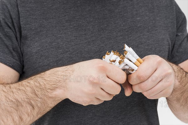 Mid section man breaking cigarettes with hands
