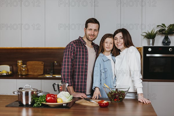 Mother father with daughter posing kitchen