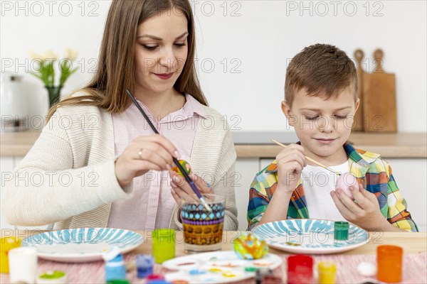 Mother son home painting eggs