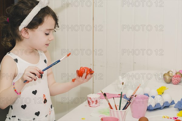 Nice girl painting egg with red