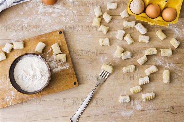 Overhead view fork preparing fresh italian pasta gnocchi wooden desk