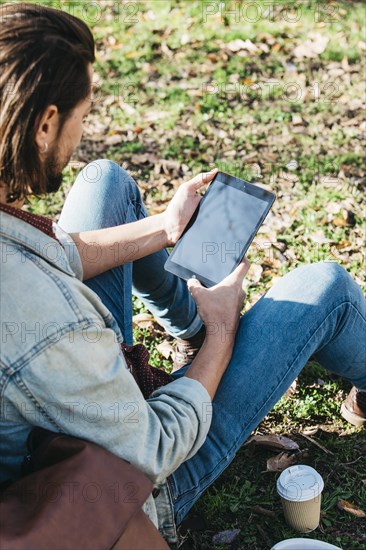 Overhead view man sitting park using mobile phone