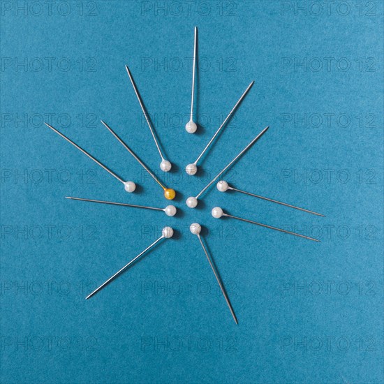 Overhead view yellow push pins with white pins blue background