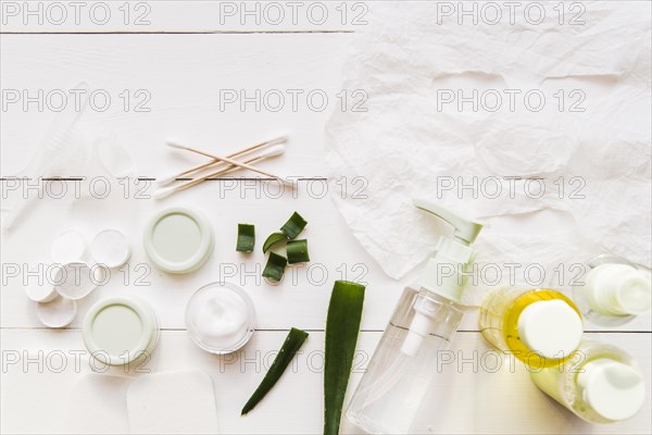 Paper sheet face mask cotton swabs moisturizer aloevera white wooden plank