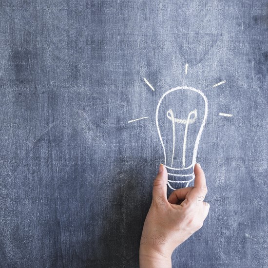 Person holding light bulb drawn chalkboard