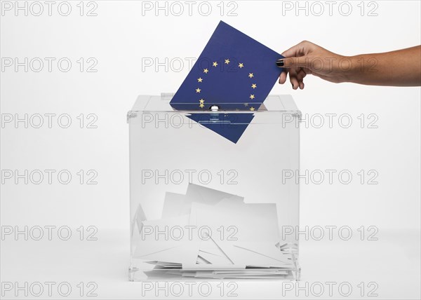 Person putting european union flag card into ballot box