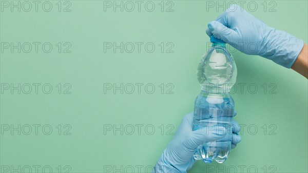 Person wearing gloves opening bottle