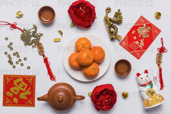 Plate with tangerines amidst chinese stuff
