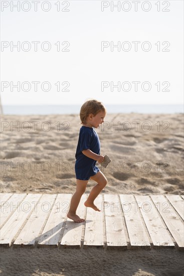 Playful little boy running beach