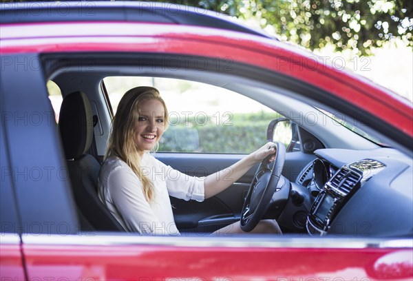 Portrait happy woman sitting inside car