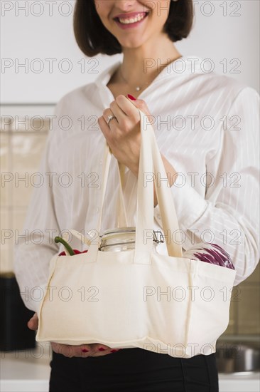 Portrait woman holding organic groceries bag