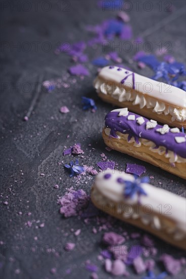 Purple macaroons with lavender flowers dark black background