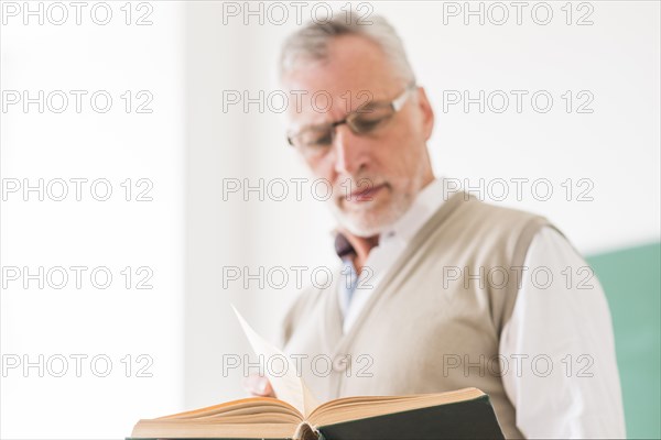 Senior male professor glasses reading book