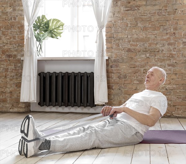 Senior man working out with elastic band