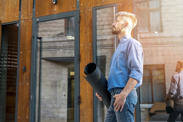 Side view architect holding blueprints