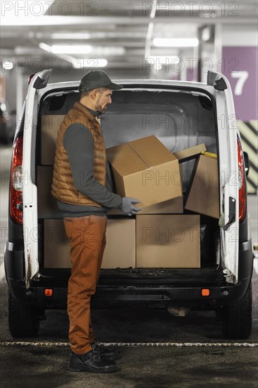 Side view man loading car with packages