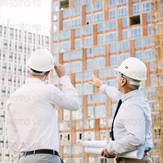 Side view man pointing building scaffolding