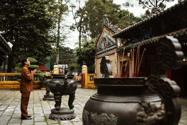 Side view man praying temple with incense