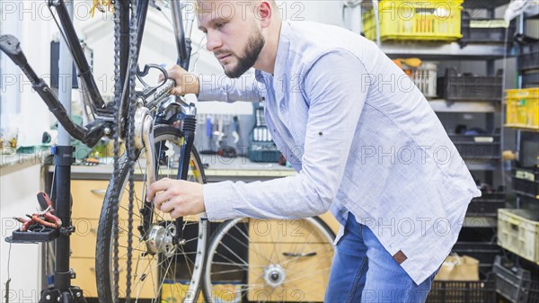 Side view man repairing bicycle