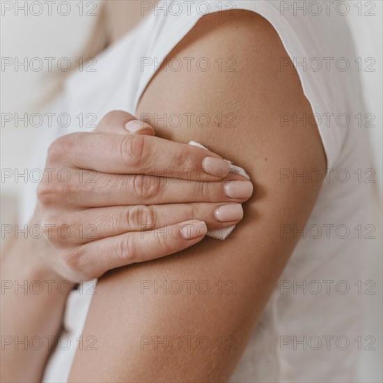 Side view woman holding her arm after getting her vaccine