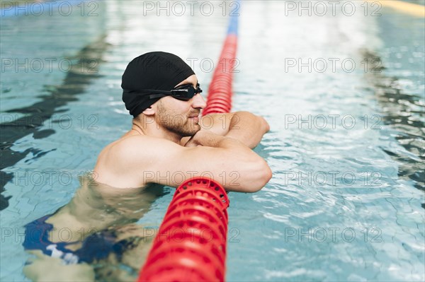 Side view young male swimming pool