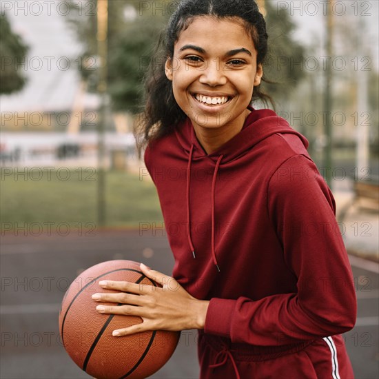 Smiley black american woman holding basketball