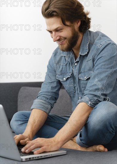 Smiley man typing laptop s keyboard
