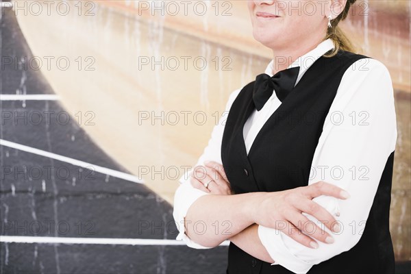 Smiley waiter holding hands waiting serve