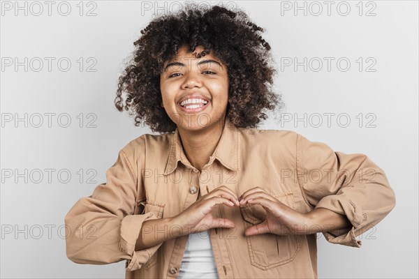 Smiling young woman making hearth sign