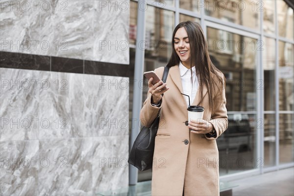 Stylish girl with coffee phone outside