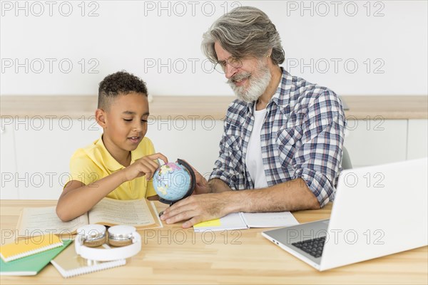 Teacher student looking earth globe