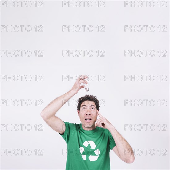 Thoughtful man holding light bulb his head