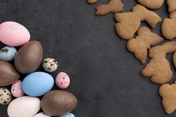 Top view chocolate easter eggs with bunny shaped cookies