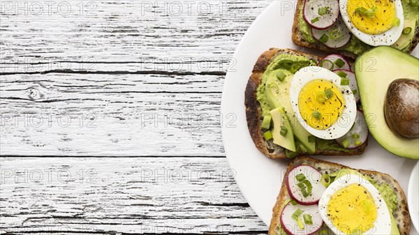 Top view egg avocado sandwiches plate with copy space