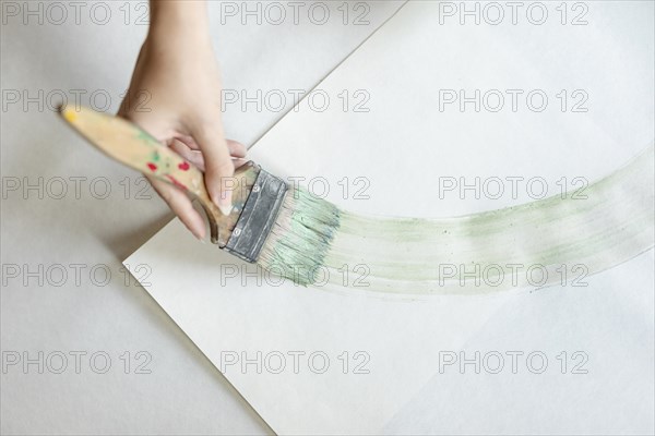 Top view woman painting with big brush