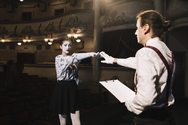 Two male female mime artist rehearsing stage auditorium