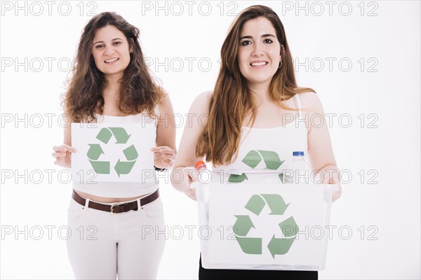 Two woman holding recycle placard crate against white background