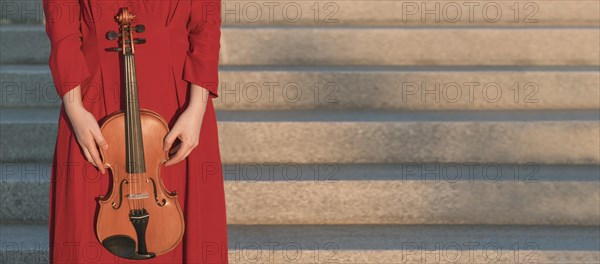 Woman holding violin steps