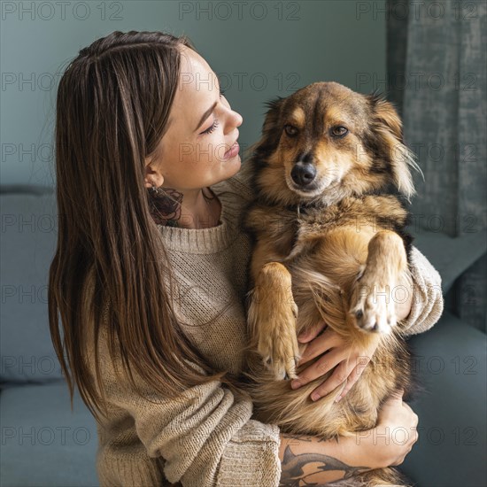 Woman home holding her cute dog during pandemic