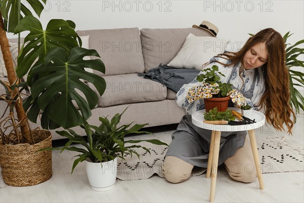 Woman home with pot plant gardening tool