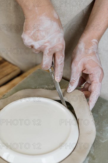 Woman making clay pot her workshop