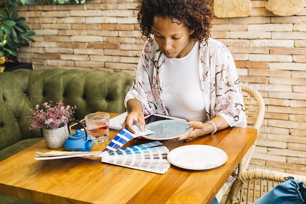 Woman matching color swatch with plate table