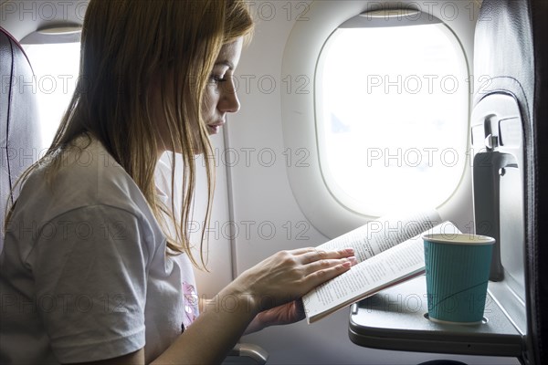 Woman reading book plane