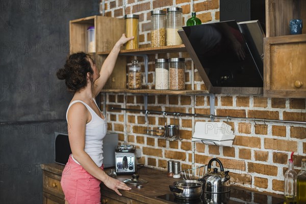 Woman taking pasta from shelf