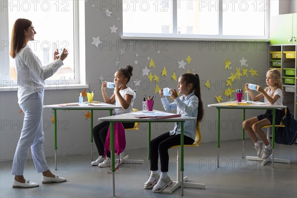 Woman teaching kids how use medical mask