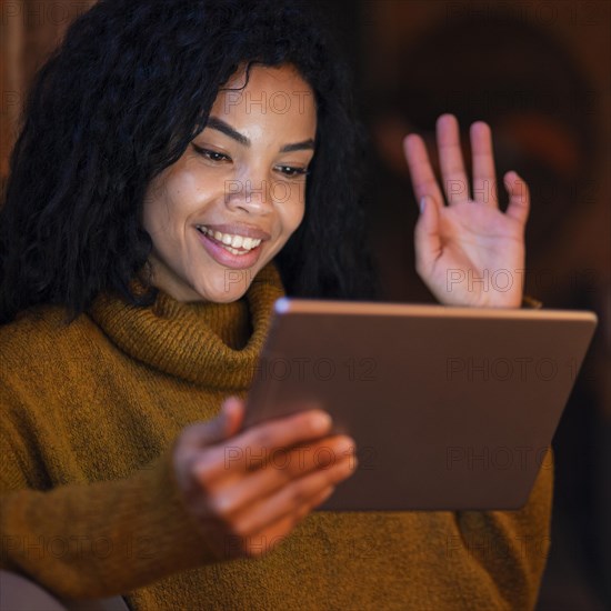 Woman using tablet coffee shop video call