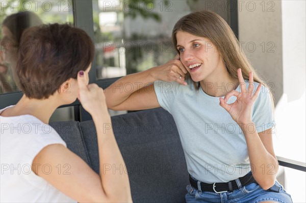 Women using sign language converse with each other