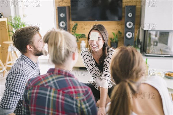 Young cheerful people guessing cards