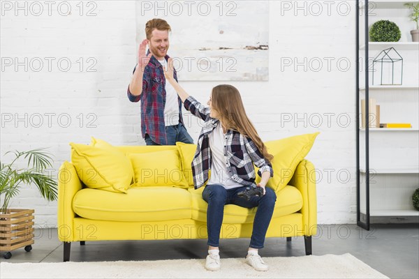 Young couple giving high five each other after playing video game